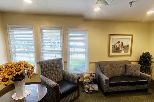 Lounge area featuring two chairs, a coffee table, and a painting on the wall.