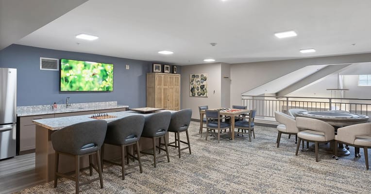 Bright common area with seating and a large TV at Solista Salem.