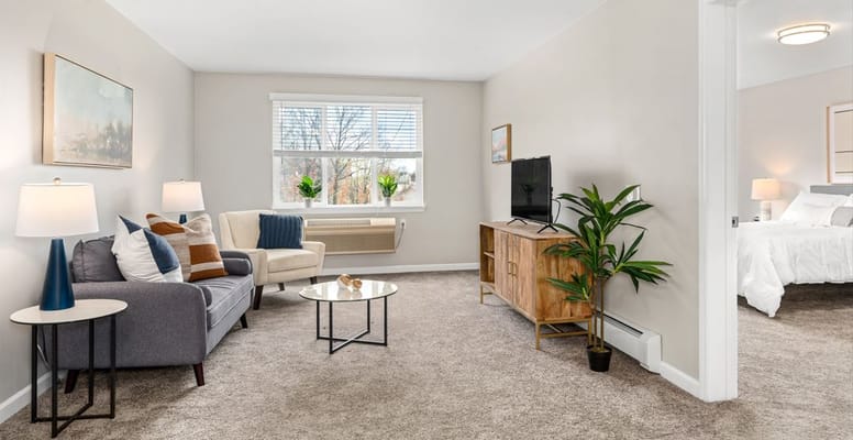 A cozy living room featuring a sofa, coffee table, and television.