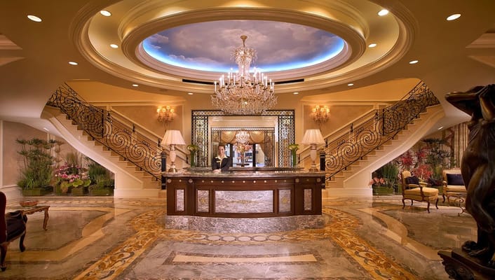 Luxurious lobby with a chandelier and elegant staircase