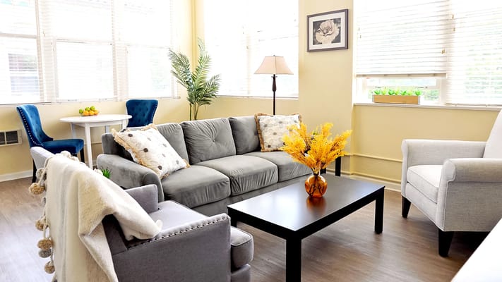 Cozy living room with gray couch, decorative pillows, and a coffee table