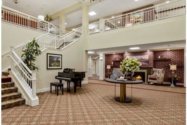 Spacious lobby with piano, plants, and comfortable seating
