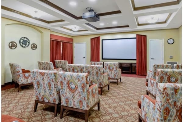 Theater room with patterned chairs and a projector screen