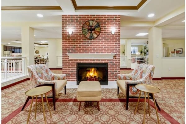 Cozy living room with a fireplace, two chairs, and a coffee table.