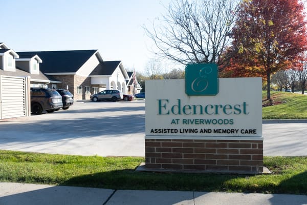 Sign for Edencrest at Riverwoods with building in background