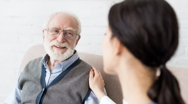 Staff member engaging with a smiling senior resident