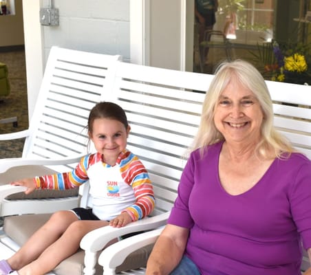 An older woman and a young girl smiling in a common area