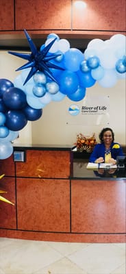 Reception area with balloon decorations and staff member