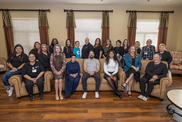 Staff members posing together in a common area
