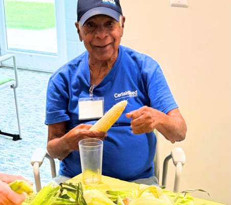 Senior resident preparing corn in an activity setting