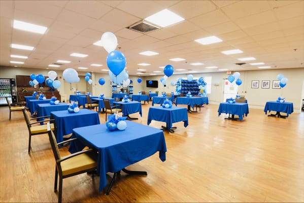 Brightly decorated common area with blue and white balloons
