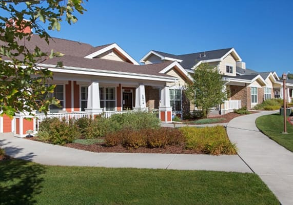 Exterior view of a senior living facility with pathways and gardens