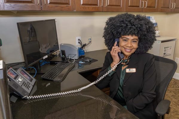 Staff member at a reception desk talking on the phone