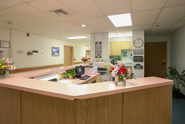 Reception area with flowers and a computer station