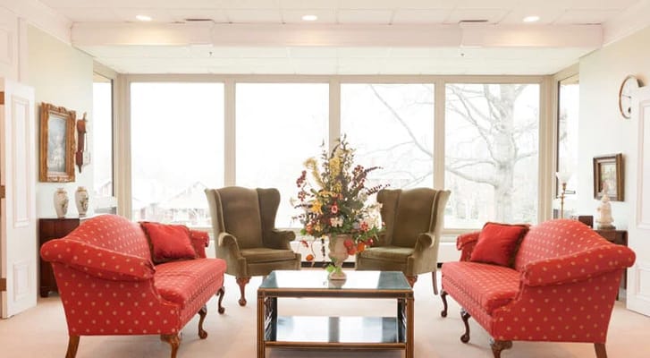 Bright common area with comfortable seating and floral arrangement
