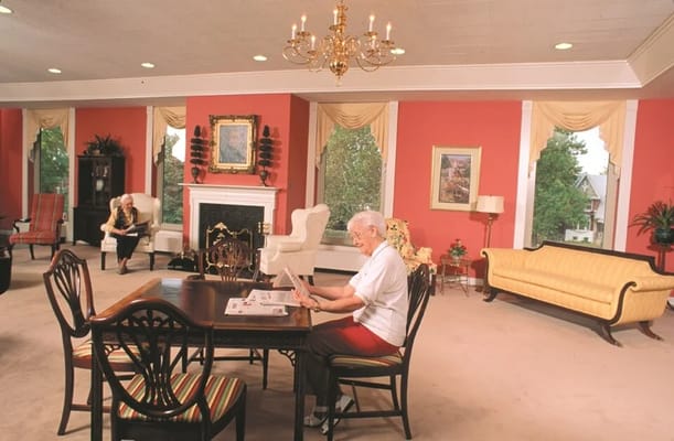 Residents enjoying a common area with reading materials