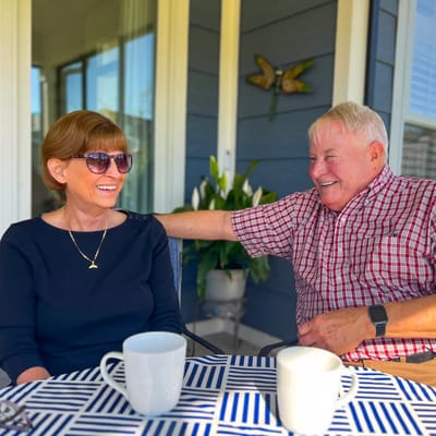 Two residents enjoying coffee on an outdoor patio