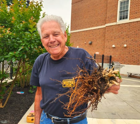 Senior resident smiling while holding a plant