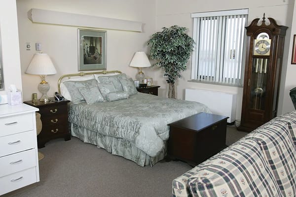 Well-furnished private resident room with bed and clock