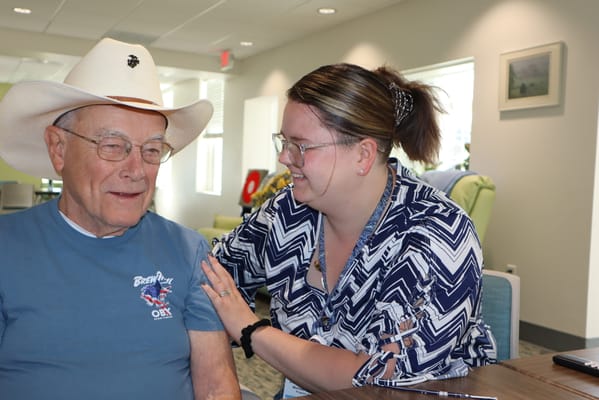 Resident interacting with staff in a bright common area
