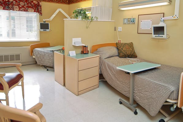 Patient room with two beds and a shared bedside table