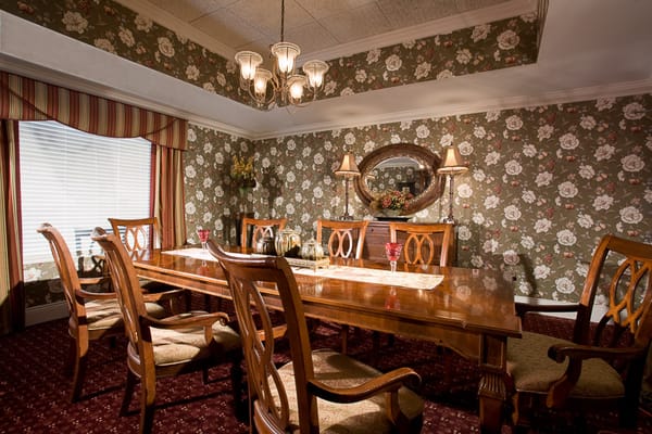Elegant dining room with floral wallpaper and wooden table