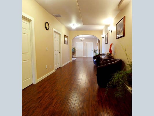 Bright indoor hallway with wooden flooring and artwork