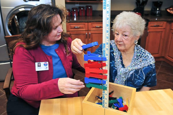 Staff assisting resident with a colorful activity