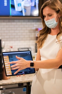 Staff member demonstrating a tablet in a dining area
