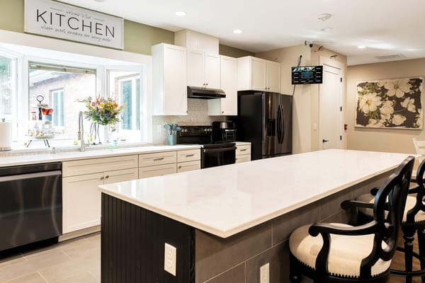 Modern kitchen with white cabinetry and marble countertops