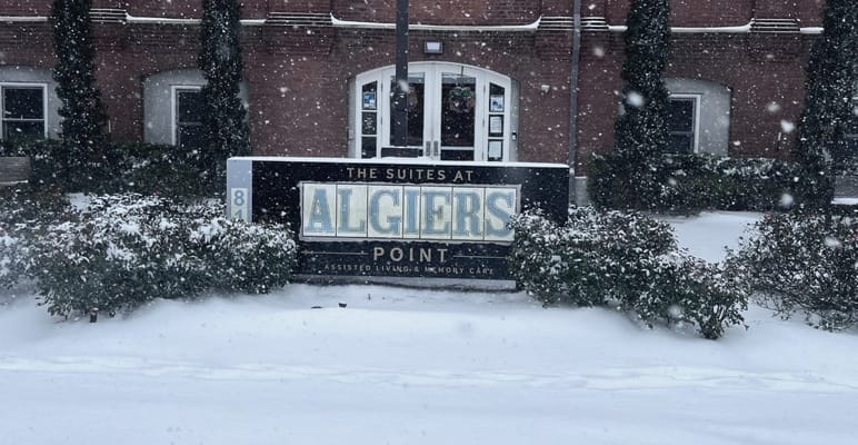 Sign of The Suites at Algiers Point in snowy weather