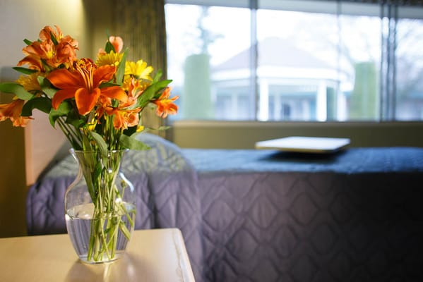 A vase of vibrant flowers on a bedside table