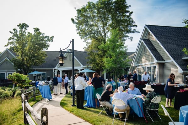 Outdoor gathering with residents and staff in a garden setting
