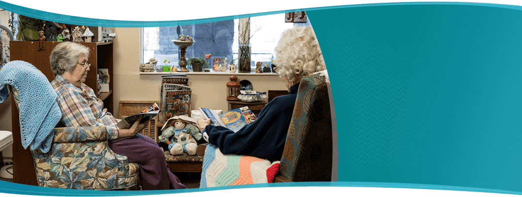 Two residents reading in a cozy common area