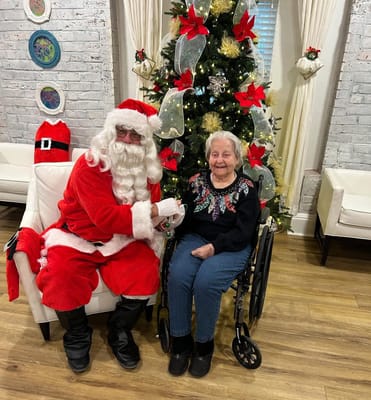 Resident with Santa Claus in a festive setting