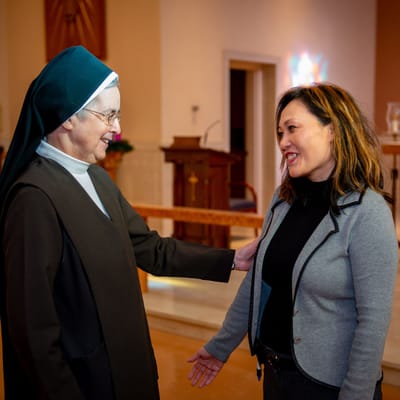 Two women engaging in conversation in a facility interior