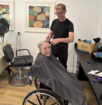 Stylist giving a haircut to a resident in a salon
