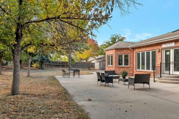 Outdoor seating area with trees and sidewalk