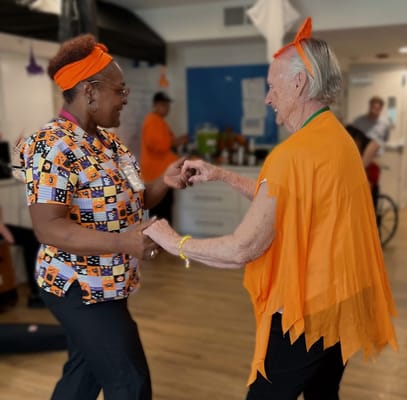 Staff and resident dancing in a vibrant common area