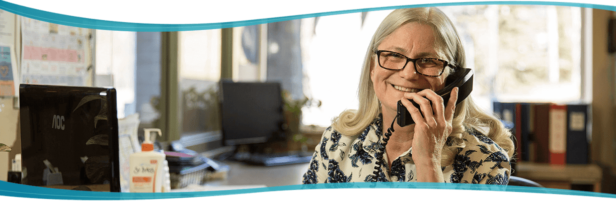 Staff member smiling on the phone in the office