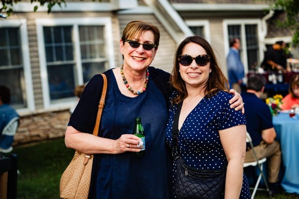 Two women smiling at an outdoor community event