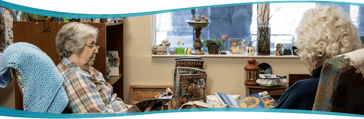 Two residents reading magazines in a cozy interior.