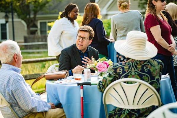 Residents and staff engaging at an outdoor event table