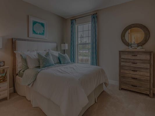 Cozy interior of a private resident room with a bed and dresser