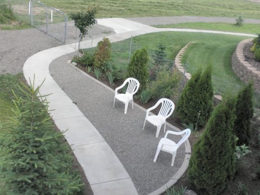 Outdoor seating area with chairs and greenery