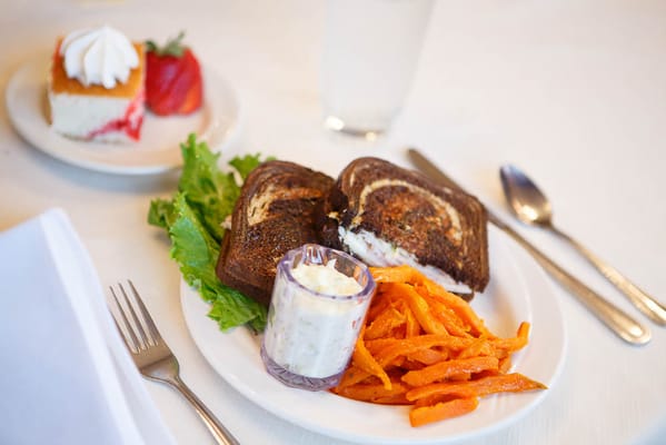 A meal plate with fish, carrots, and dessert