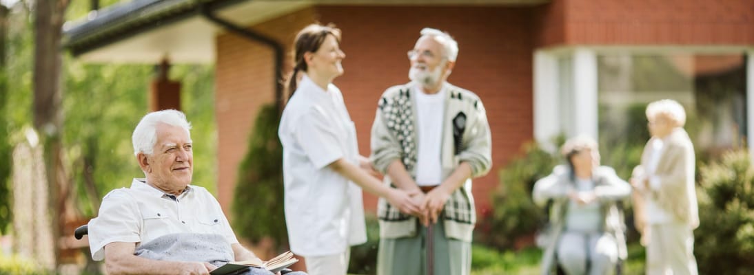 Residents interacting with staff in an outdoor garden area