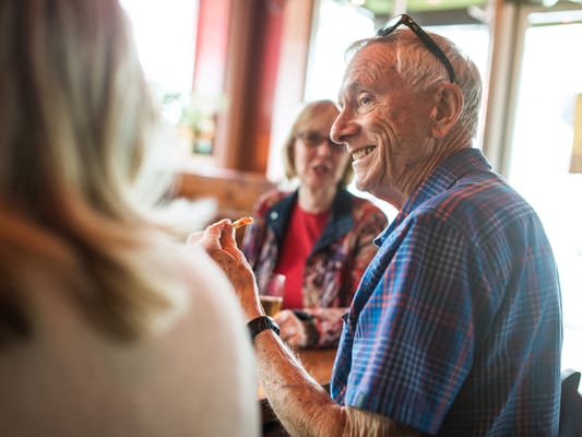 Residents engaged in conversation at a dining area