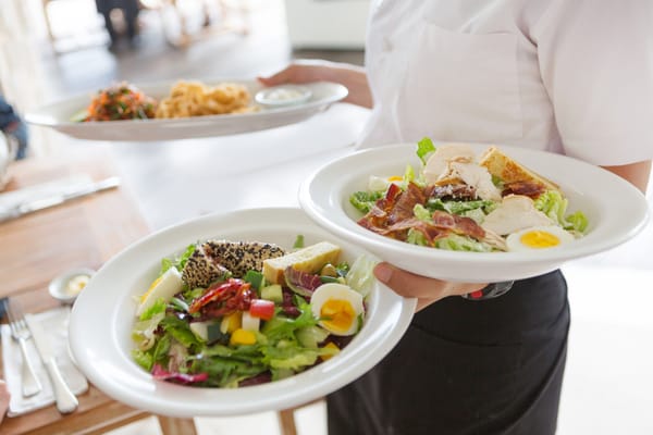 A staff member serving meals in the dining room