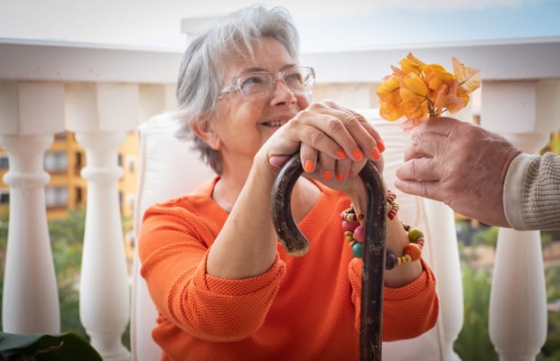 Senior woman receiving a flower in a cozy outdoor space
